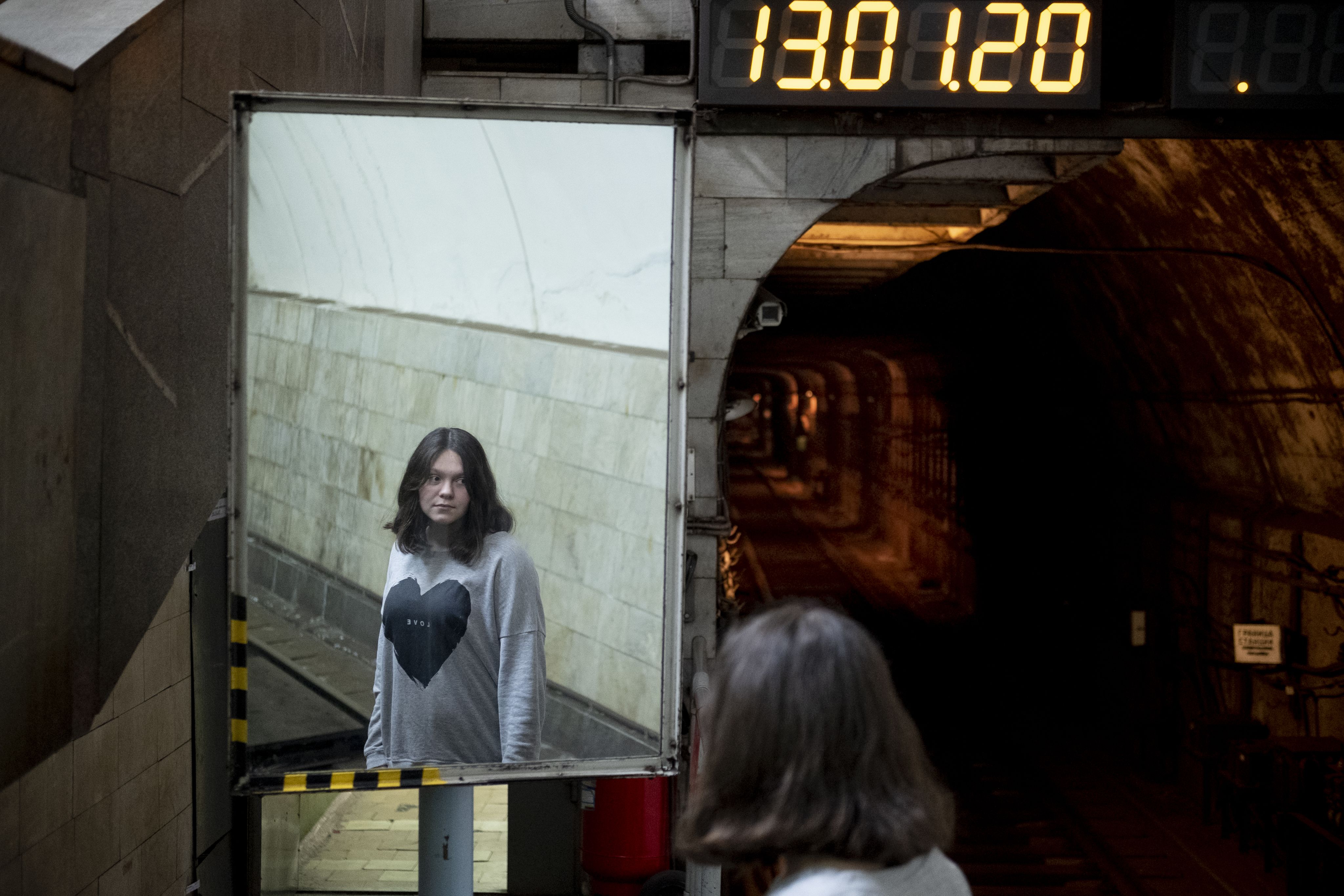 Polina stands on the platform in a subway station in Kharkiv.